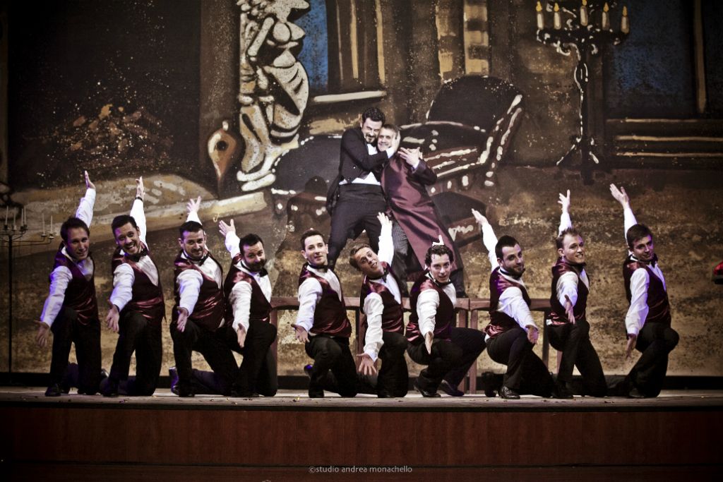 Coro maschile in gilet bordeaux con coreografia a ventaglio