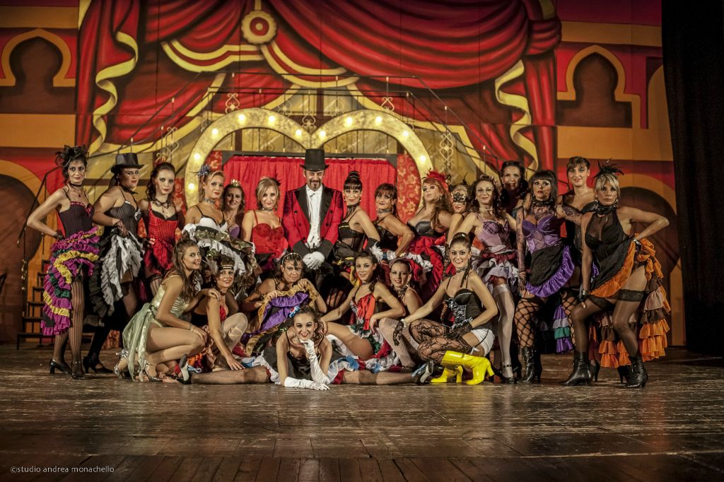 Foto di gruppo della compagnia al completo sul palco del Moulin Rouge