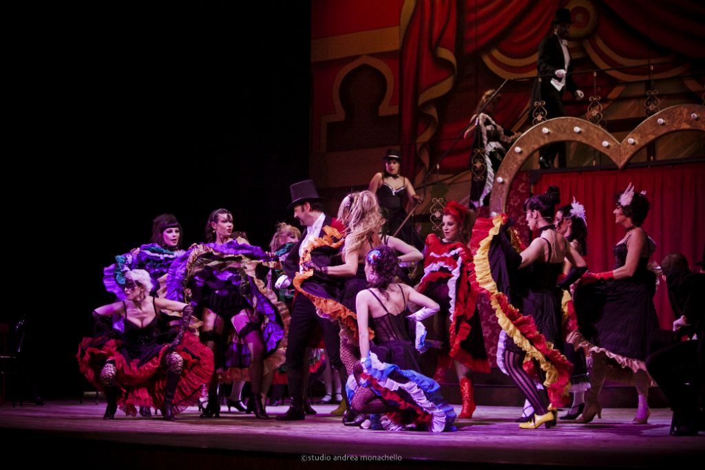 Le ballerine di can-can attorno al maestro di cerimonie in cilindro