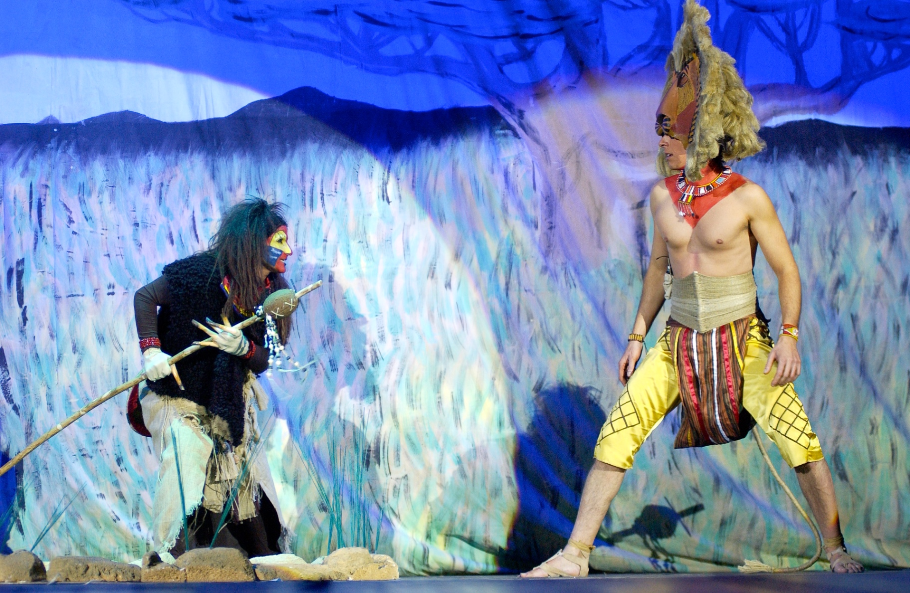 Rafiki con bastone rituale davanti a Simba nella savana blu