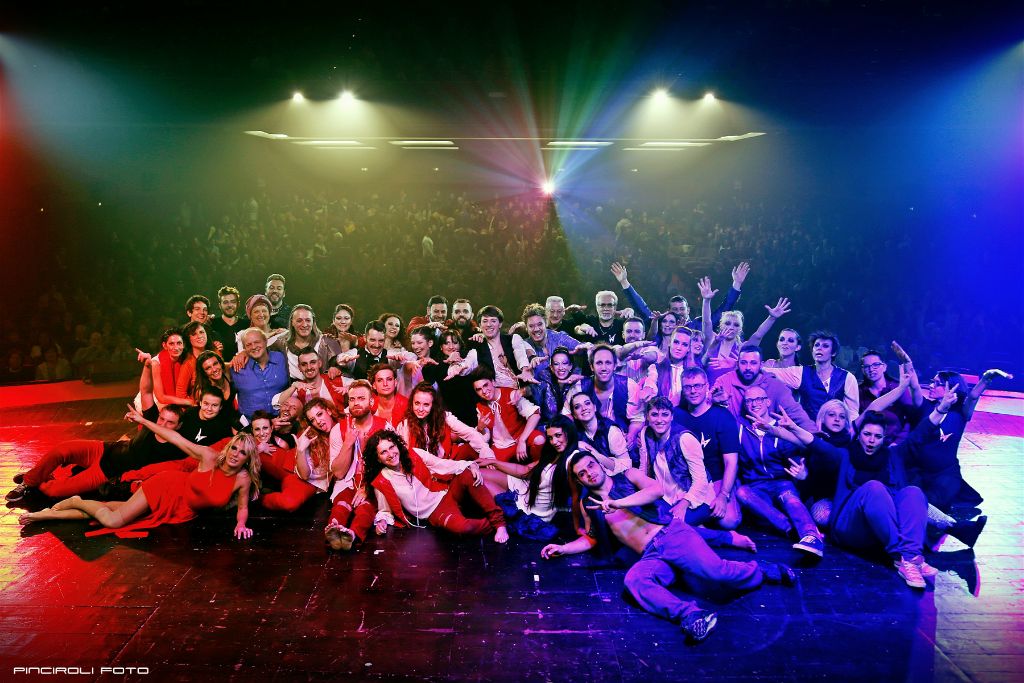 Foto di gruppo dell'intera compagnia sul palco a fine spettacolo