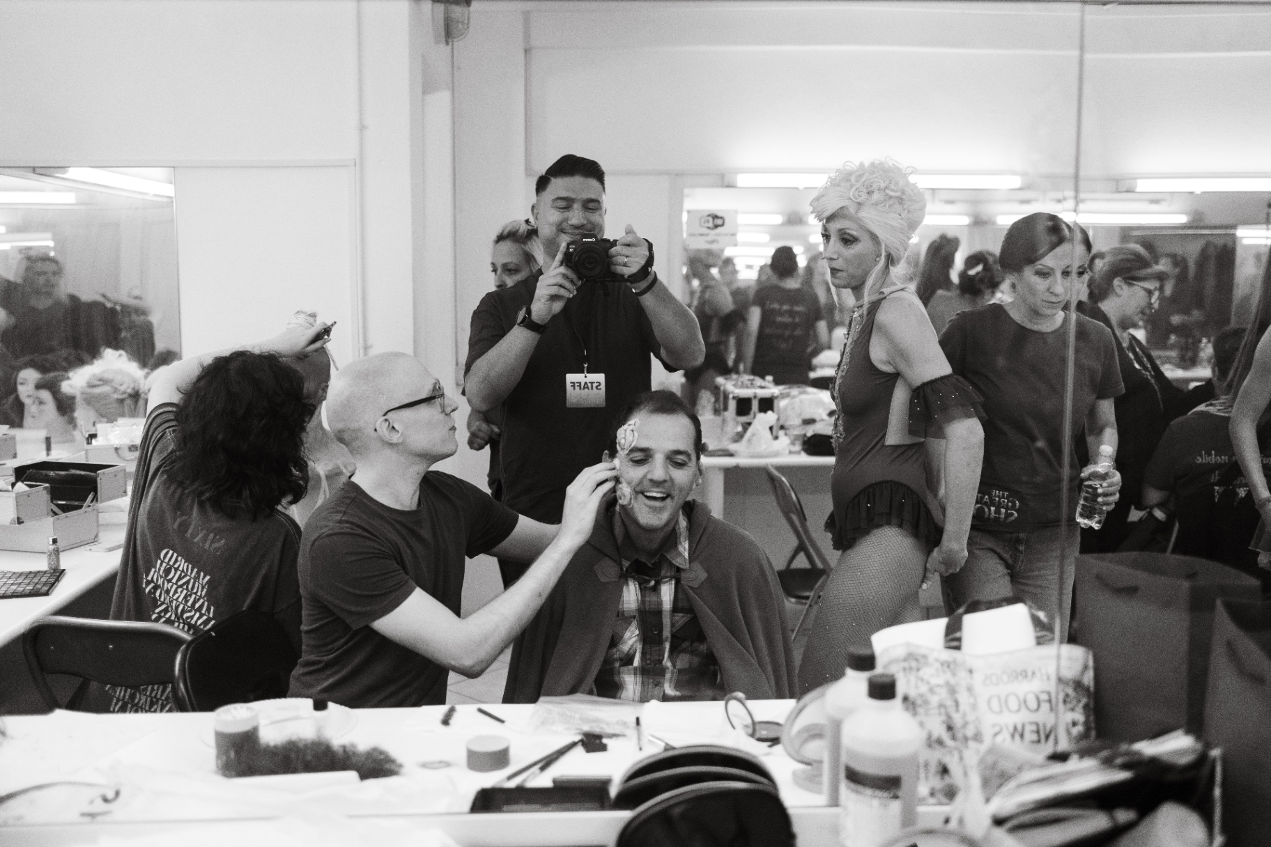 Fotografo di scena immortala truccatore e attore riflessi nello specchio del camerino tra il cast in preparazione